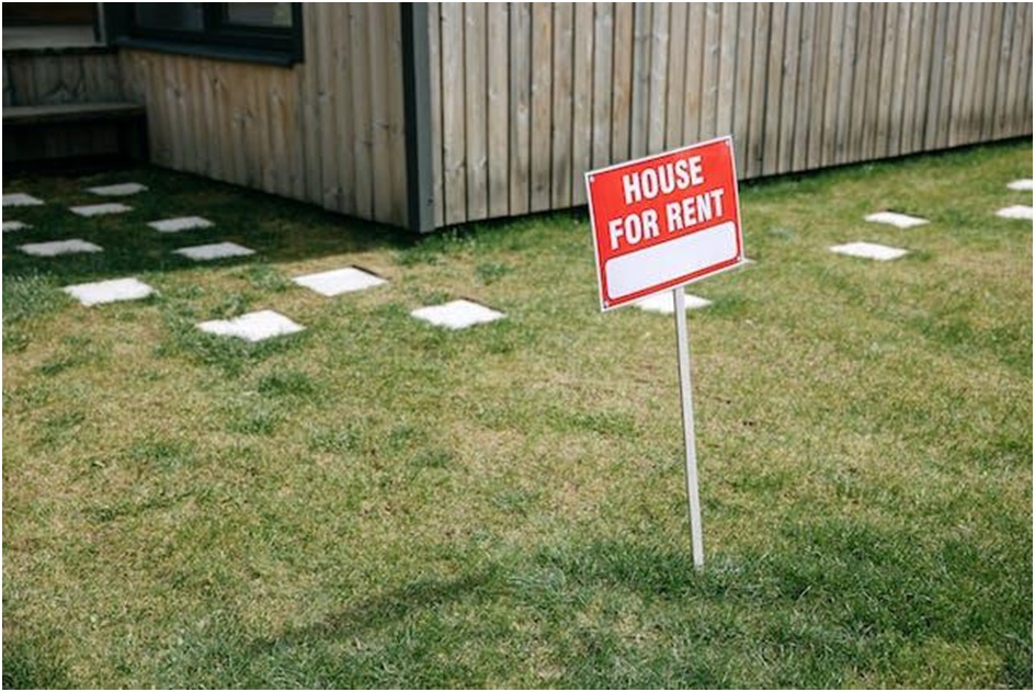 A house for rent sign on a front lawn